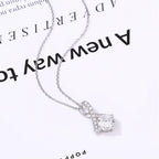 Silver pendant necklace with a twisted design and sparkling round crystal on white background