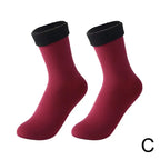 Pair of burgundy ankle socks with black cuffs on white background
